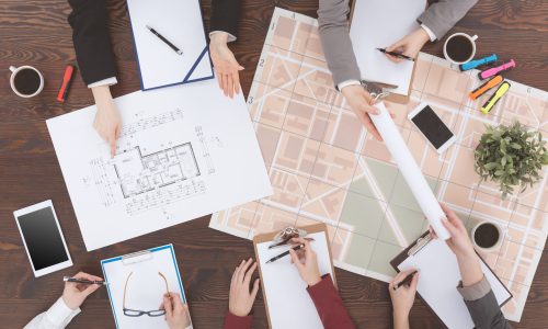 Workers of real estate agency analyzing architecture project, top view